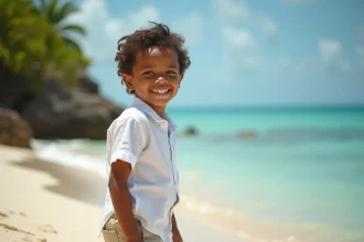 Jeune garçon martiniquais souriant sur une plage tropicale, illustrant les prénoms rares et caractériels des garçons de Martinique